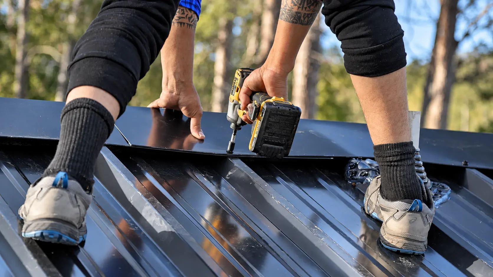 Close-up of a roofer fastening metal roof panels