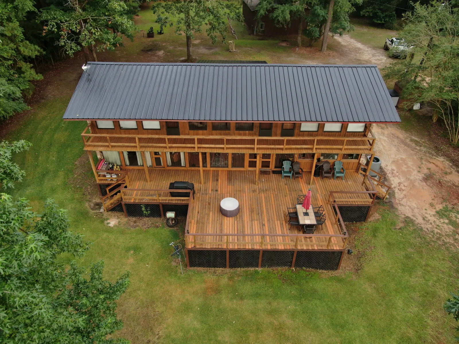 Aerial view of a metal roof on a two-story home with a deck in East Texas