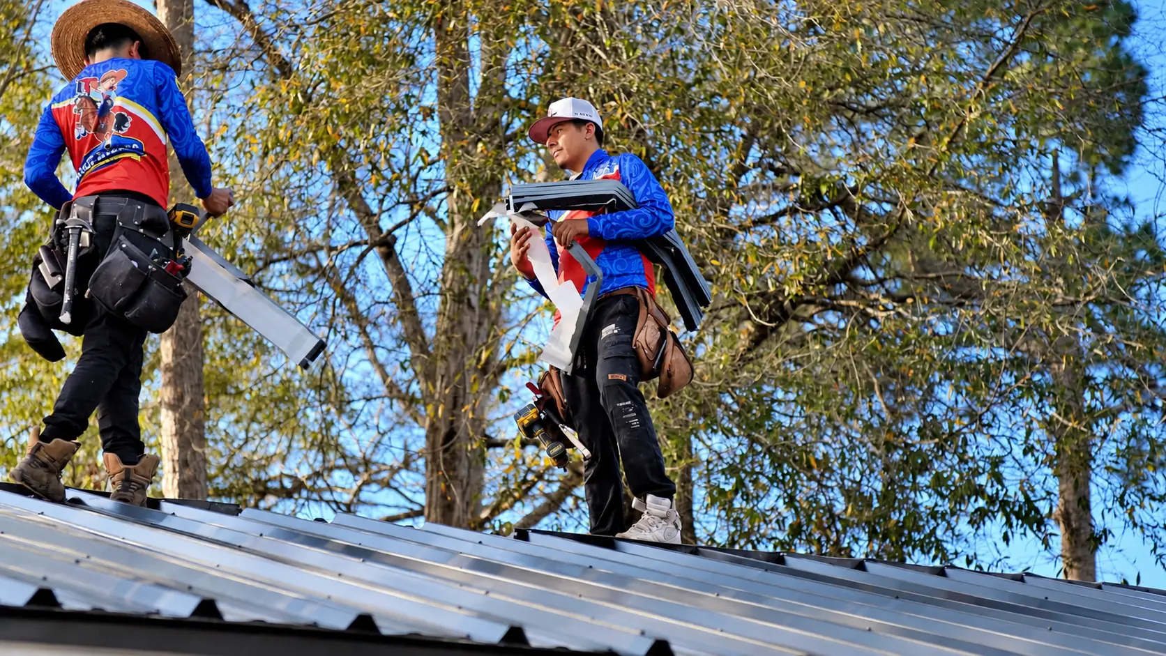 Roofer carrying metal roof trim across the roof