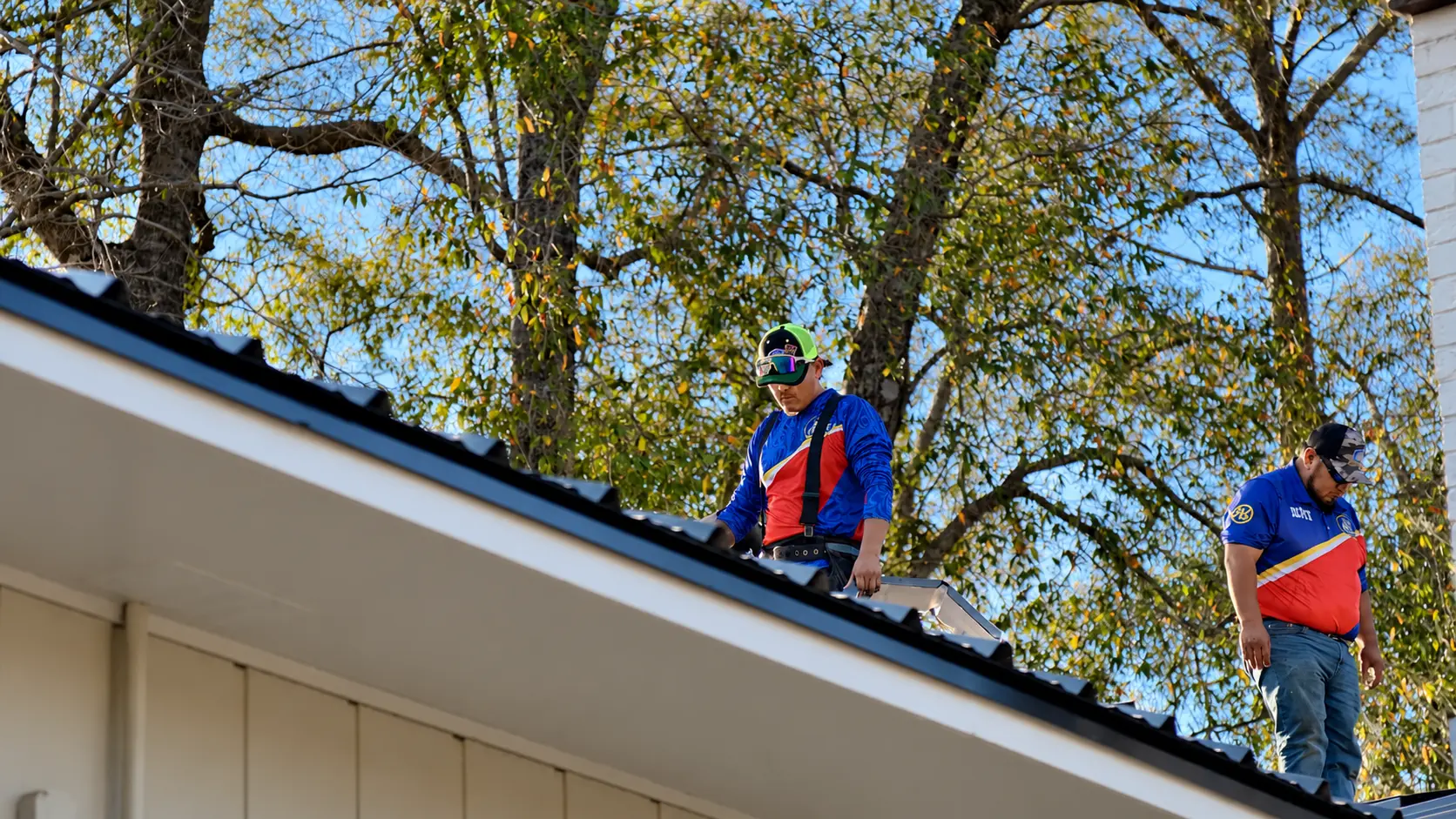 Roofer inspecting the edge of a metal roof