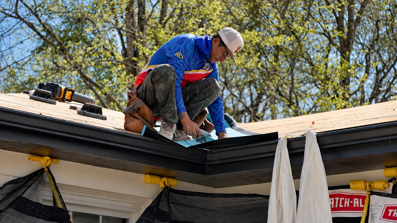 Roofer installing drip edge along the gutter line