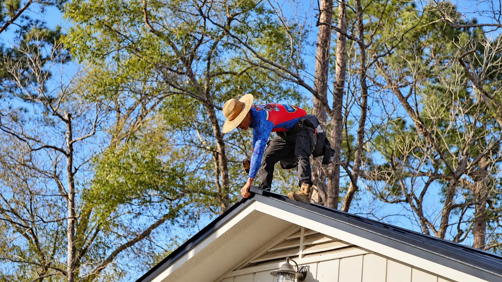 Roofer working along the ridge of a metal roof